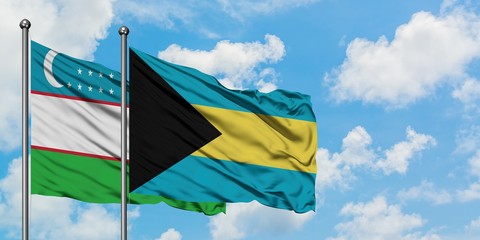 Uzbekistan and Bahamas flag waving in the wind against white cloudy blue sky together. Diplomacy concept, international relations.