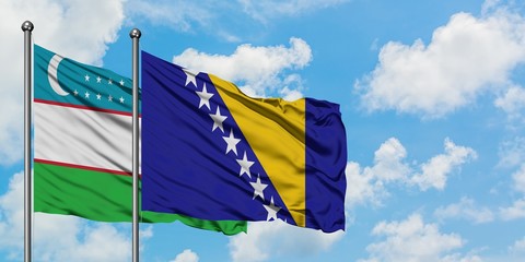 Uzbekistan and Bosnia Herzegovina flag waving in the wind against white cloudy blue sky together. Diplomacy concept, international relations.