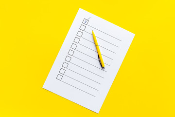Empty check list ready to fill on yellow background top view