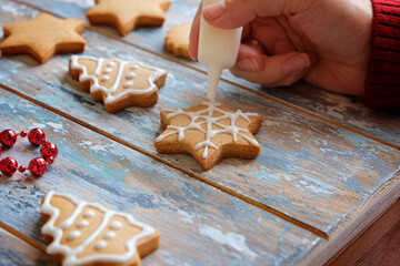 Making christmas ginger cookies with white glaze decoration, close up