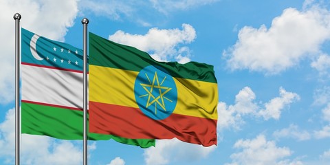 Uzbekistan and Ethiopia flag waving in the wind against white cloudy blue sky together. Diplomacy concept, international relations.