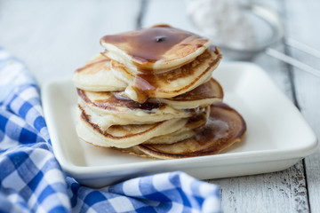 Tasty breakfast. Homemade pancakes with crushed berry, honey or maple syrup on white grey  background.