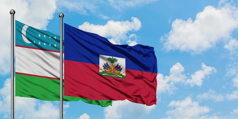Uzbekistan and Haiti flag waving in the wind against white cloudy blue sky together. Diplomacy concept, international relations.