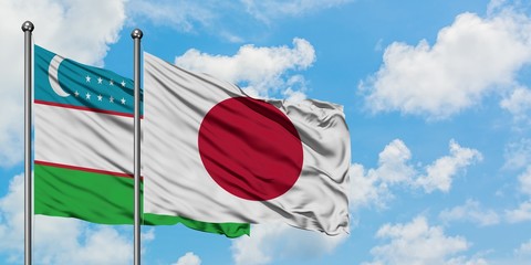 Uzbekistan and Japan flag waving in the wind against white cloudy blue sky together. Diplomacy concept, international relations.