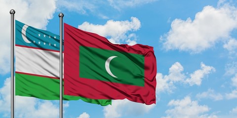Uzbekistan and Maldives flag waving in the wind against white cloudy blue sky together. Diplomacy concept, international relations.