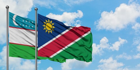 Uzbekistan and Namibia flag waving in the wind against white cloudy blue sky together. Diplomacy concept, international relations.
