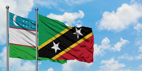 Uzbekistan and Saint Kitts And Nevis flag waving in the wind against white cloudy blue sky together. Diplomacy concept, international relations.