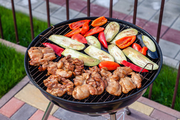 Making barbeque, having lunch at the nature. Assortment various barbecue food grill meat, bbq party fest, grilled chicken breast meat fillet, fresh vegetables, red pepper, marinate zucchini