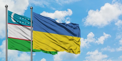 Uzbekistan and Ukraine flag waving in the wind against white cloudy blue sky together. Diplomacy concept, international relations.