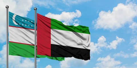 Uzbekistan and United Arab Emirates flag waving in the wind against white cloudy blue sky together. Diplomacy concept, international relations.