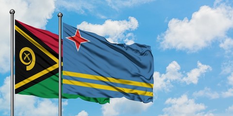 Vanuatu and Aruba flag waving in the wind against white cloudy blue sky together. Diplomacy concept, international relations.