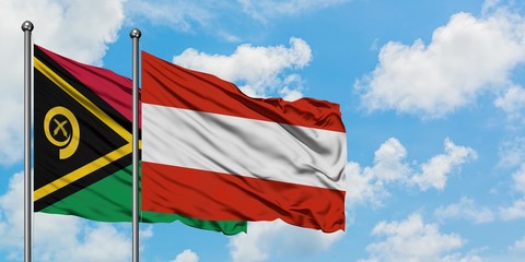 Vanuatu and Austria flag waving in the wind against white cloudy blue sky together. Diplomacy concept, international relations.