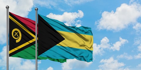 Vanuatu and Bahamas flag waving in the wind against white cloudy blue sky together. Diplomacy concept, international relations.