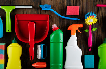 Autumn house cleaning theme.  Colorful cleaning products on rustic wooden table. Top view shot. Place for typography.