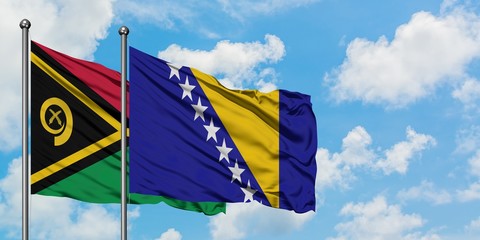 Vanuatu and Bosnia Herzegovina flag waving in the wind against white cloudy blue sky together....