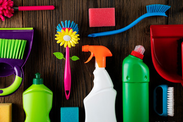 Autumn house cleaning theme.  Colorful cleaning products on rustic wooden table. Top view shot....