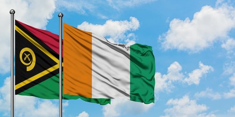 Vanuatu and Cote D'Ivoire flag waving in the wind against white cloudy blue sky together. Diplomacy...