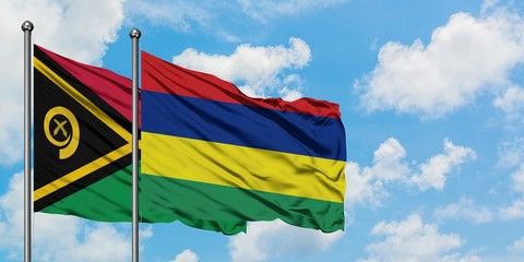 Vanuatu and Mauritius flag waving in the wind against white cloudy blue sky together. Diplomacy concept, international relations.