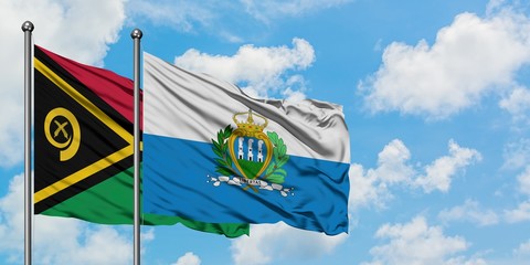 Vanuatu and San Marino flag waving in the wind against white cloudy blue sky together. Diplomacy...
