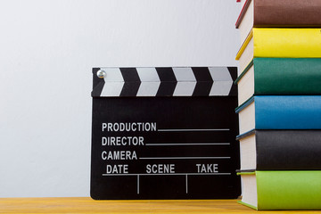 A pile of books and a movie clapper