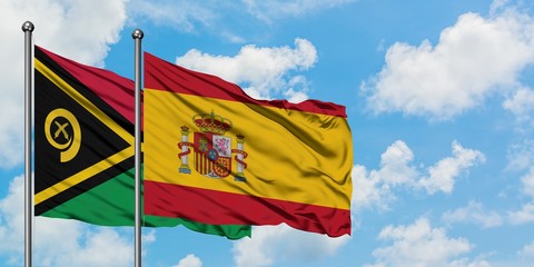 Vanuatu and Spain flag waving in the wind against white cloudy blue sky together. Diplomacy concept, international relations.
