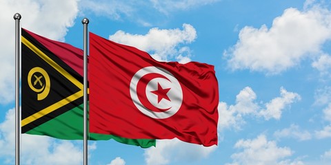 Vanuatu and Tunisia flag waving in the wind against white cloudy blue sky together. Diplomacy concept, international relations.