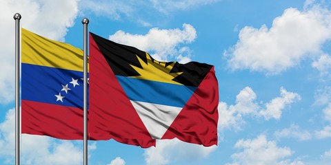 Venezuela and Antigua and Barbuda flag waving in the wind against white cloudy blue sky together. Diplomacy concept, international relations.