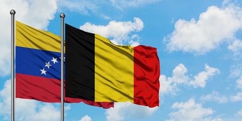 Venezuela and Belgium flag waving in the wind against white cloudy blue sky together. Diplomacy concept, international relations.