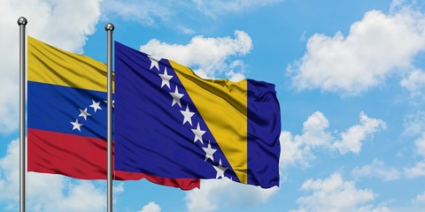 Venezuela and Bosnia Herzegovina flag waving in the wind against white cloudy blue sky together. Diplomacy concept, international relations.