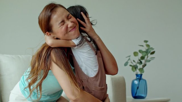 Young mother holding and hugging little daughter with love