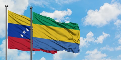 Venezuela and Gabon flag waving in the wind against white cloudy blue sky together. Diplomacy concept, international relations.