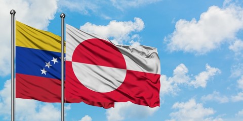Venezuela and Greenland flag waving in the wind against white cloudy blue sky together. Diplomacy concept, international relations. © sezerozger