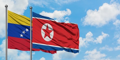 Venezuela and North Korea flag waving in the wind against white cloudy blue sky together. Diplomacy concept, international relations.