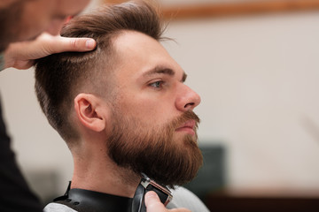 Obraz premium haircut beard typewriter. beard trimmer. Barber services. The man in the barbershop