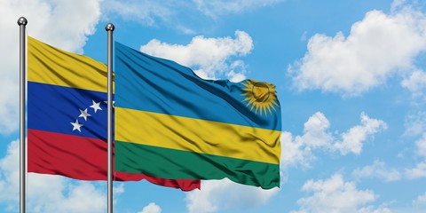 Venezuela and Rwanda flag waving in the wind against white cloudy blue sky together. Diplomacy concept, international relations.