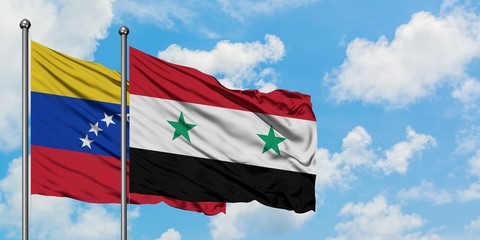 Venezuela and Syria flag waving in the wind against white cloudy blue sky together. Diplomacy...