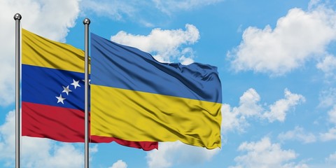 Venezuela and Ukraine flag waving in the wind against white cloudy blue sky together. Diplomacy concept, international relations.