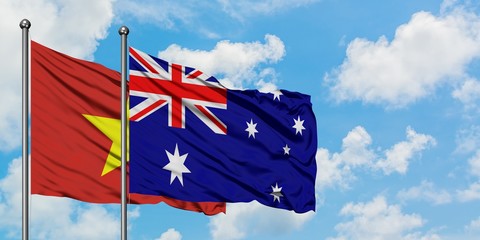 Vietnam and Australia flag waving in the wind against white cloudy blue sky together. Diplomacy concept, international relations.