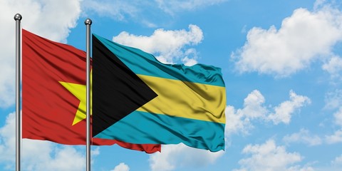 Vietnam and Bahamas flag waving in the wind against white cloudy blue sky together. Diplomacy concept, international relations.