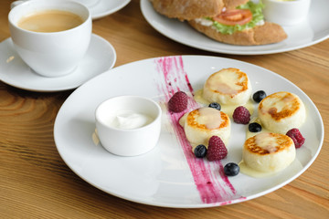 Delicious curd cheesecakes with raspberry and blueberry berry sauce. restaurant food concept