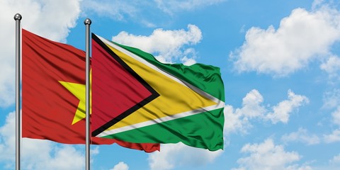 Vietnam and Guyana flag waving in the wind against white cloudy blue sky together. Diplomacy concept, international relations.
