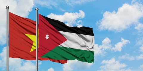 Vietnam and Jordan flag waving in the wind against white cloudy blue sky together. Diplomacy concept, international relations.