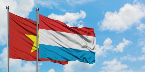 Vietnam and Luxembourg flag waving in the wind against white cloudy blue sky together. Diplomacy concept, international relations.
