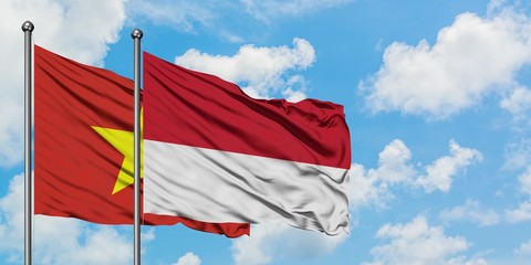 Vietnam and Monaco flag waving in the wind against white cloudy blue sky together. Diplomacy concept, international relations.