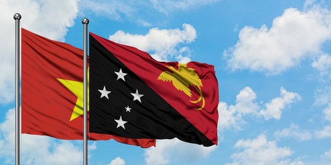 Vietnam and Papua New Guinea flag waving in the wind against white cloudy blue sky together. Diplomacy concept, international relations.