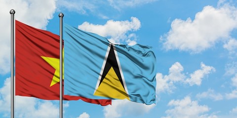 Vietnam and Saint Lucia flag waving in the wind against white cloudy blue sky together. Diplomacy concept, international relations.