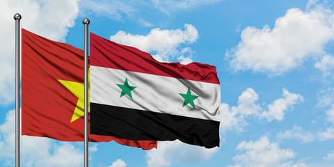 Vietnam and Syria flag waving in the wind against white cloudy blue sky together. Diplomacy concept, international relations.