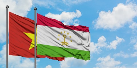 Vietnam and Tajikistan flag waving in the wind against white cloudy blue sky together. Diplomacy concept, international relations.