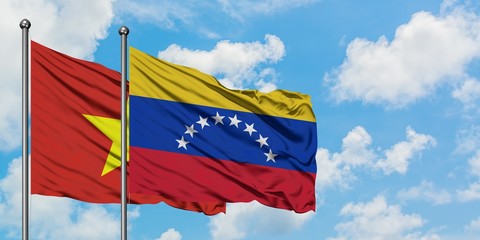 Vietnam and Venezuela flag waving in the wind against white cloudy blue sky together. Diplomacy concept, international relations.