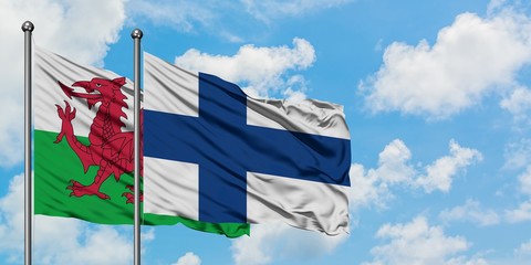 Wales and Finland flag waving in the wind against white cloudy blue sky together. Diplomacy concept, international relations.